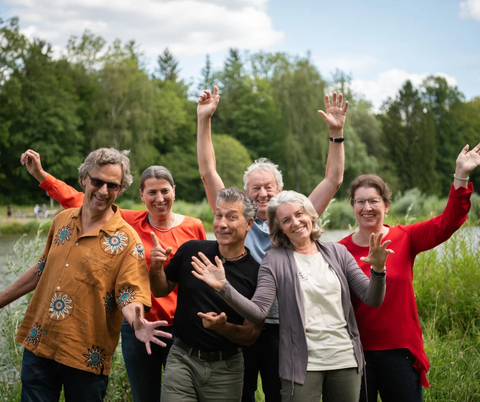 Das Leocor-Team jubelt mit erhobenen Armen am Seeufer
