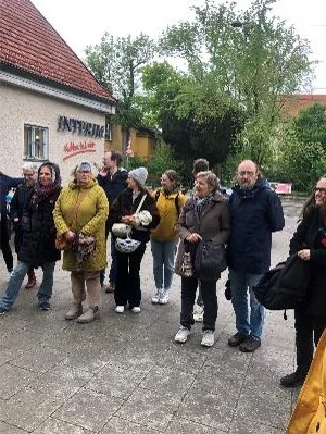 Gruppe von Menschen steht auf einer Straße vor einem Haus