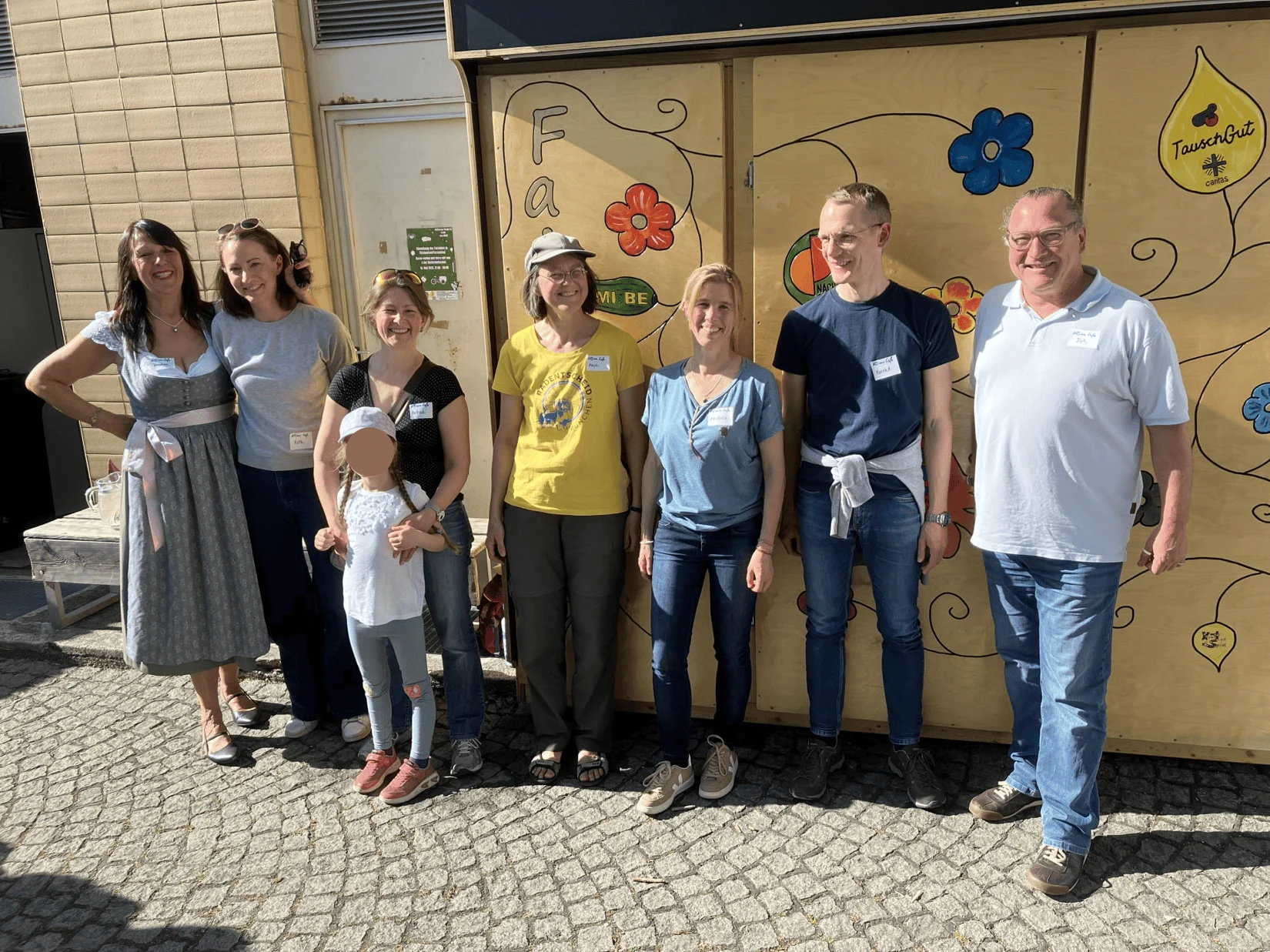Gruppe von Menschen posiert vor einer bunt gestalteten Wand