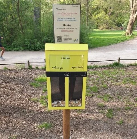 Gelbe Sammelbox an einem Pfosten neben einem Weg