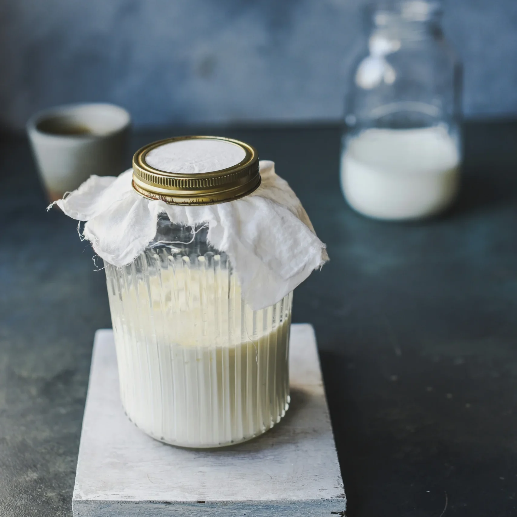 Glas mit Milchkefir, mit einem Tuch abgedeckt