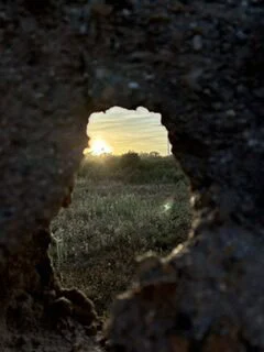 Öffnung in einer dunklen Mauer mit Blick ins Licht